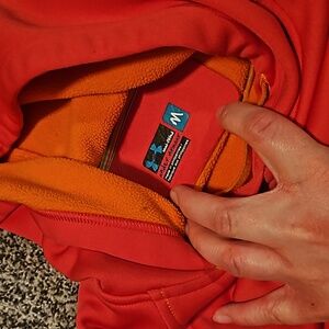 Pink/orange under Armour hoodie. Has small pocket. It looks and feels very warm